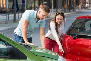 Eine junge Frau zeigt die Unfallschäden. Bildquelle: ©Andrey Popov. Fotolia.com